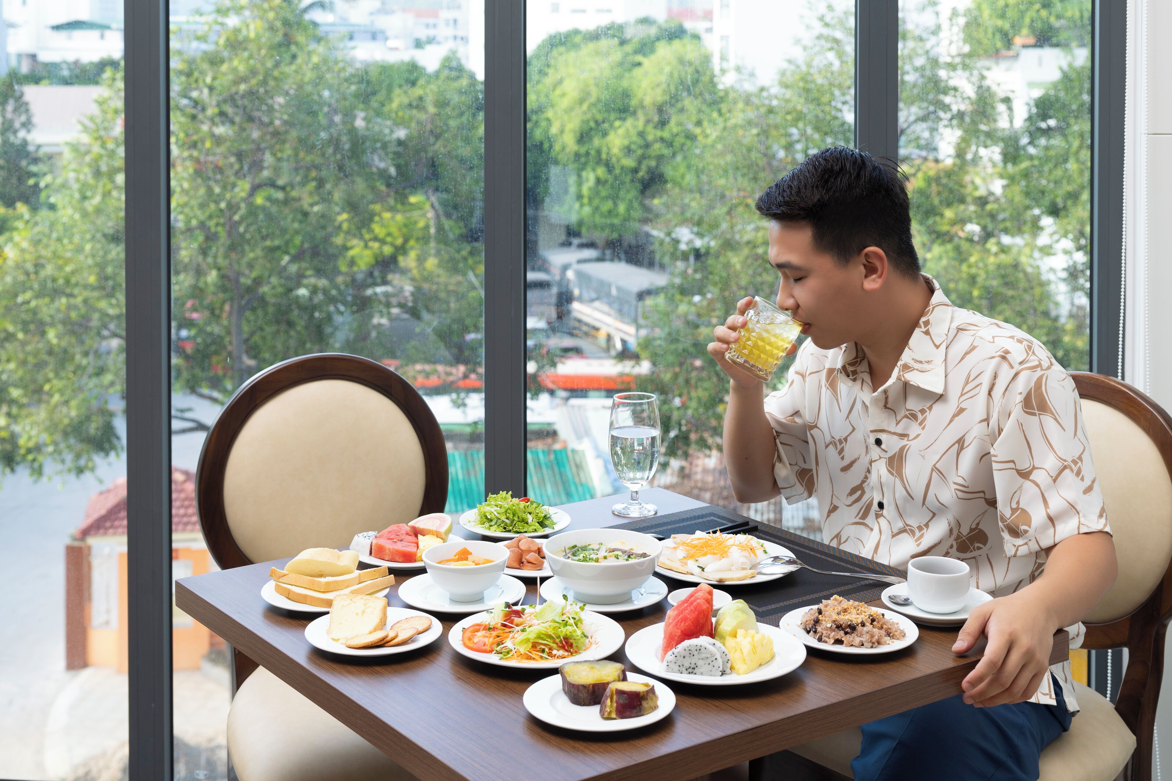 A dining table with various dishes and a person eating.