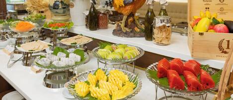 Un buffet proposant une variété de plats et agrémenté d’un coq décoratif.