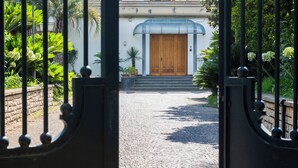 A cobblestone pathway leading to a building with a wooden door and a blue awning. - Gargiulo Suites (Piano di Sorrento)