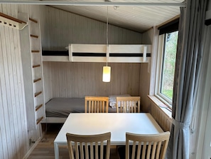 A bunk bed with a hanging light, a table with chairs, and a window with curtains. - Wonderful 100 sqm holiday home600m from the sea (Gilleleje)