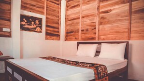 A bedroom with a wooden headboard, a bed with white linens, and a decorative blanket. - Ocean View Beach Resort (Kudawa)