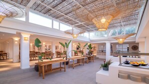 A spacious indoor area with high ceilings, natural light, and wooden furniture.