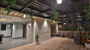 A spacious lobby with a high ceiling, modern lighting, and seating areas.