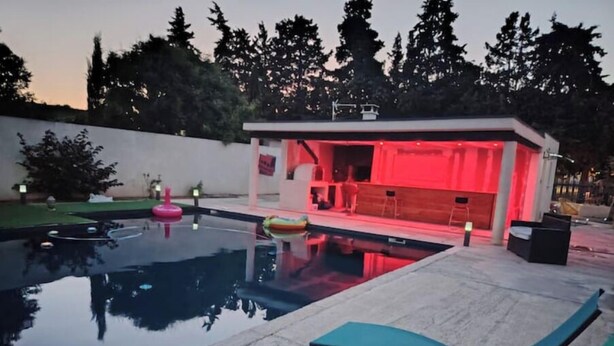 A swimming pool with lounge chairs, a small bar area, and a wooden deck. - 1 Bedroom Apartment in Beauvoisin (Beauvoisin)