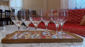 Una bandeja con cuatro copas de vino sobre una mesa con mantel de encaje.