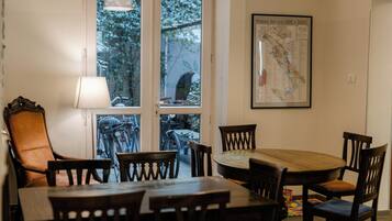 A dining area with a round table and chairs, a lamp, and a map on the wall.