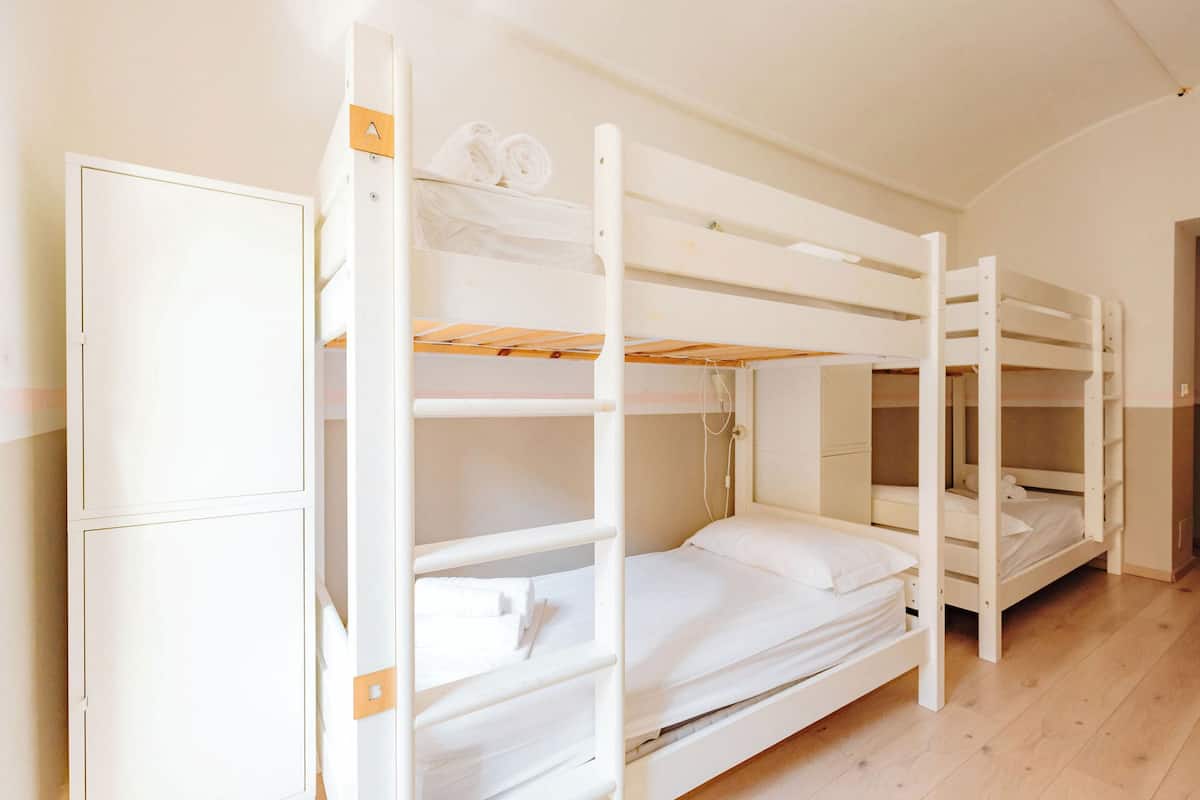 A bunk bed room with a wardrobe and a door.