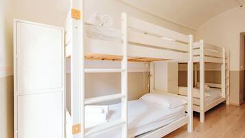 Ein Schlafzimmer mit Etagenbetten, einem Schrank und einer Tür.