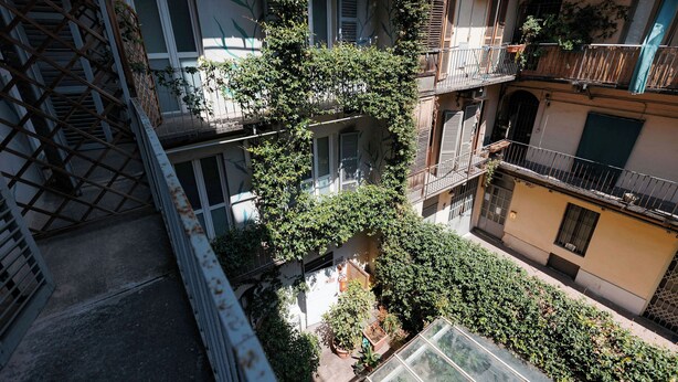 A multi-story residential building with balconies, a staircase, and potted plants. - Tomato Urban Retreat (Turin)