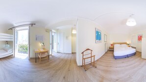 A room with a bunk bed, a desk with a chair, a small table with a lamp, and a bed with a nightstand. - Tomato Urban Retreat (Turin)