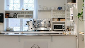 Una cocina con luces colgantes, un ventanal y un refrigerador.