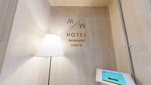 A hotel sign with 'M W HOTEL SHINJUKU TOKYO' and a digital check-in kiosk. - M/W HOTEL (Tokyo)