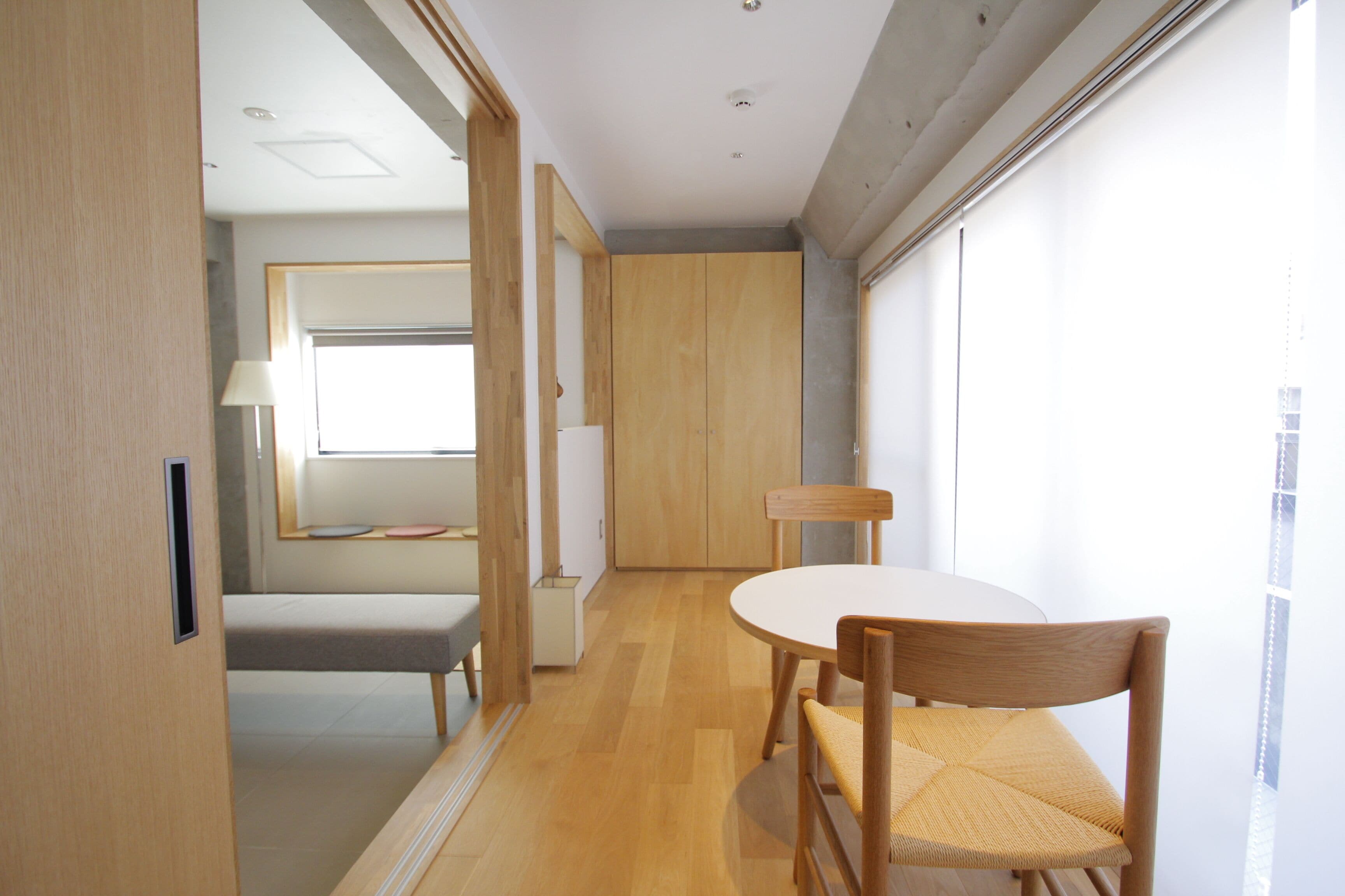 A modern room with a wooden floor, a round table, and a bench.