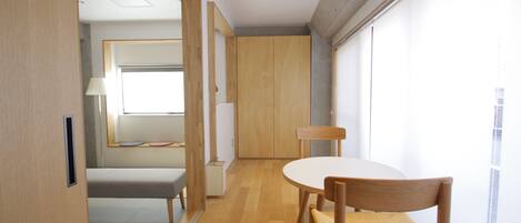 A modern room with a wooden floor, a round table, and a bench.