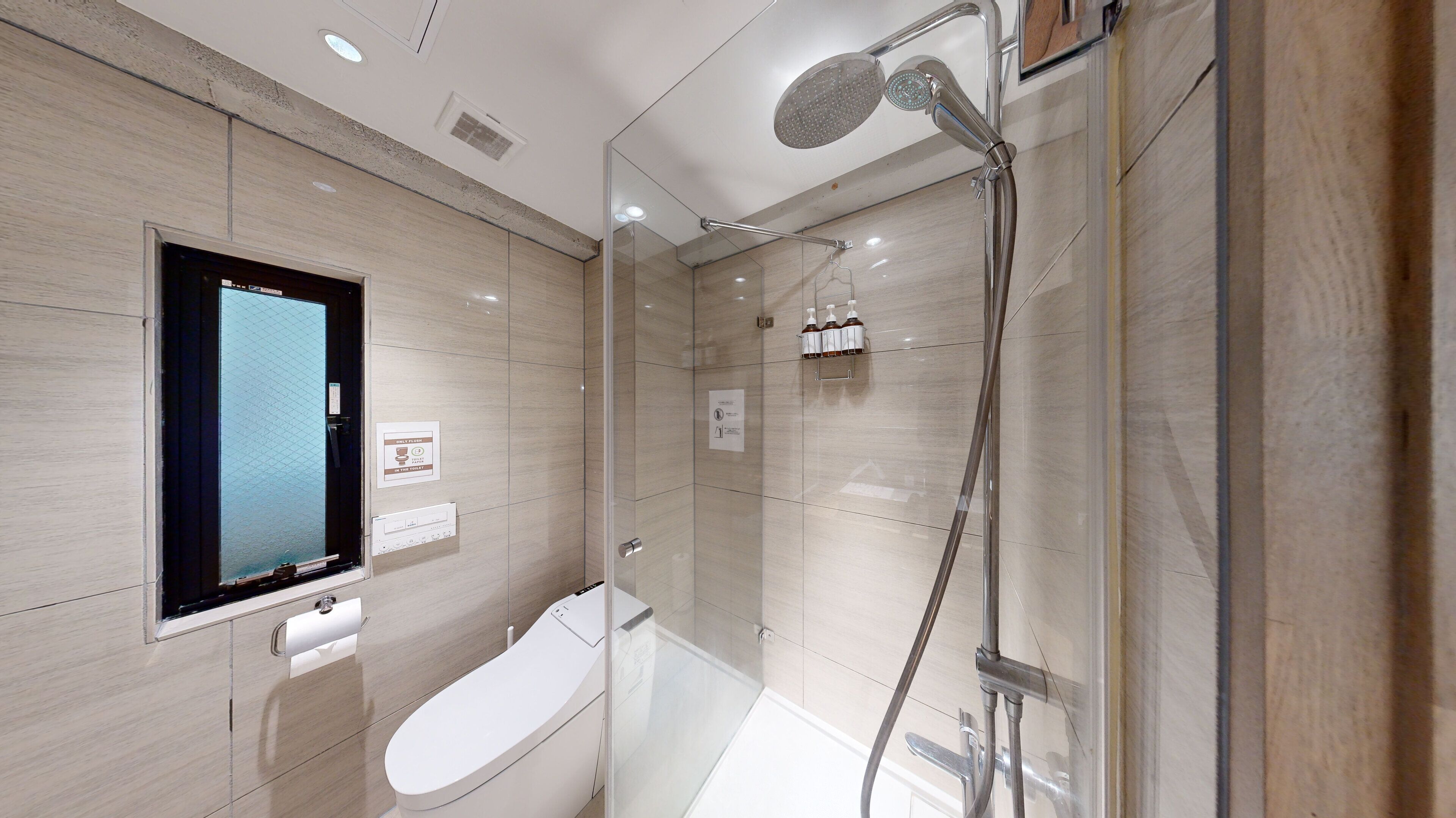 A modern bathroom with a glass-enclosed shower, a toilet, and a sink.