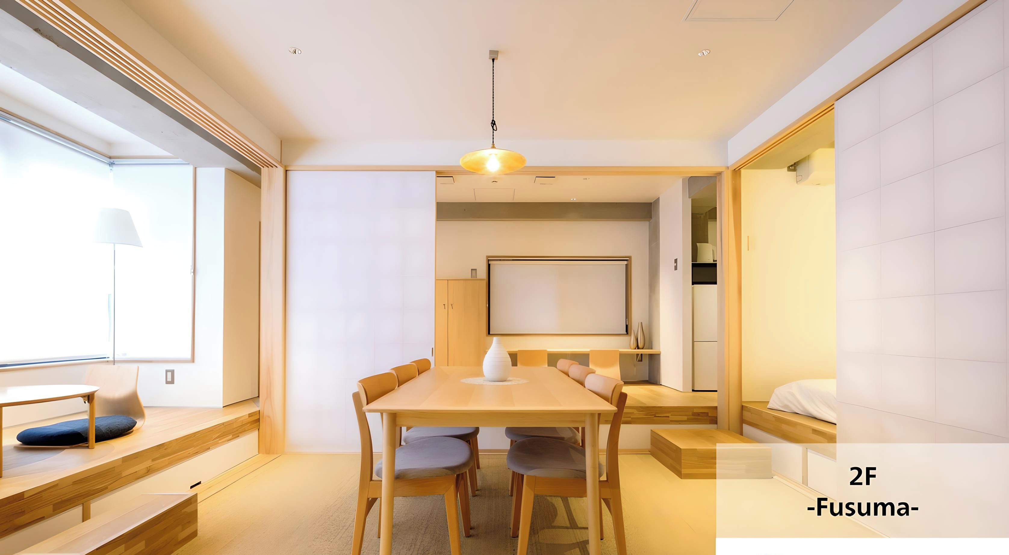 Una habitación moderna y luminosa con una mesa de madera para comer, asientos cómodos y un amplio ventanal que deja entrar luz natural.