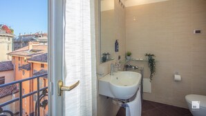 A modern bathroom with a large mirror, a white sink, and a toilet.