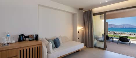 Une chambre d’hôtel moderne équipée d’un canapé-lit, d’une table d’appoint en bois et d’une cloison en verre.