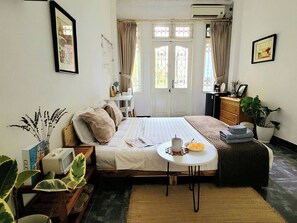 A bedroom with a bed, bedside table, dresser, and a window with curtains. - Tiny homes  (Hanoi)