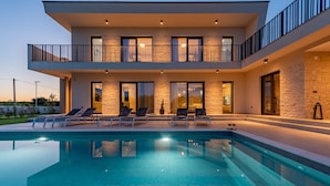 A modern two-story house with a swimming pool, outdoor seating, and a stone facade. - Villa Intrada ZadarVillas (Sukošan)