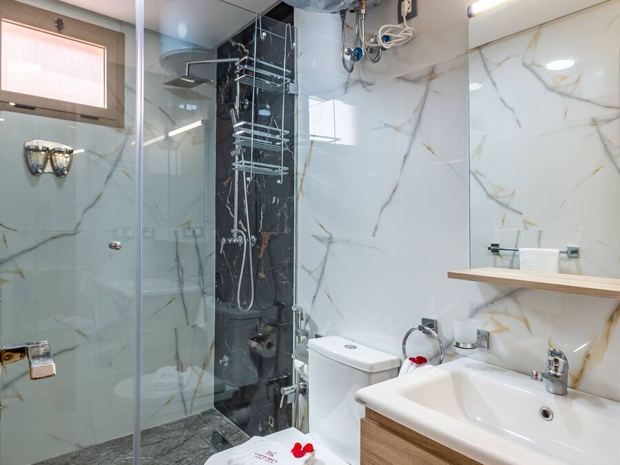 Une salle de bain moderne avec une douche à parois de verre, des toilettes blanches et un meuble-lavabo en bois avec un évier.