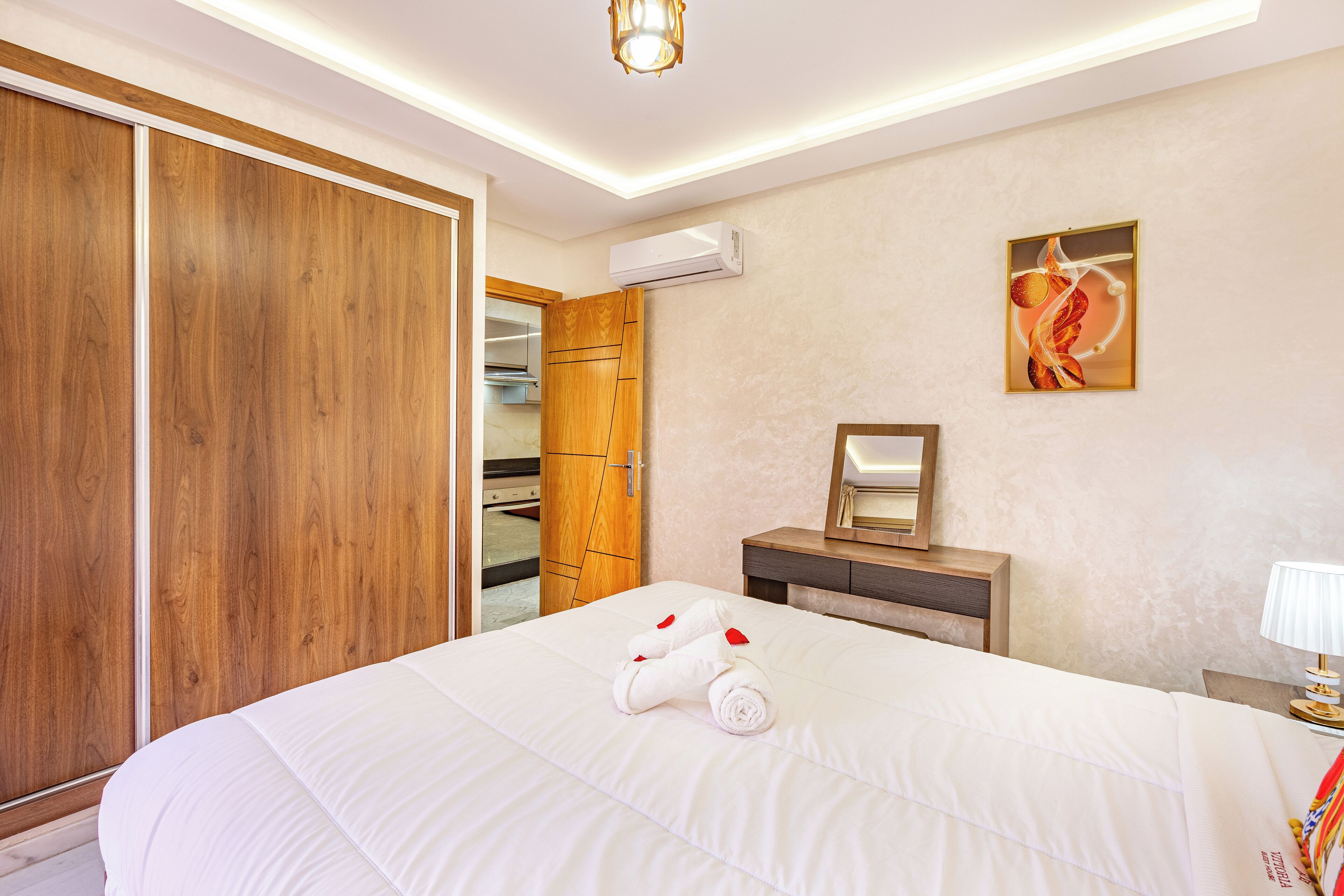 Habitación de hotel con una cama grande, armario de madera y un espejo en la pared.