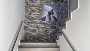 A staircase with a modern design, featuring a patterned wall and a framed artwork. - Level Suites #3 Premium Suite (Sosúa)