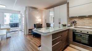 A modern kitchen with a glass island, wooden cabinets, and a built-in oven.