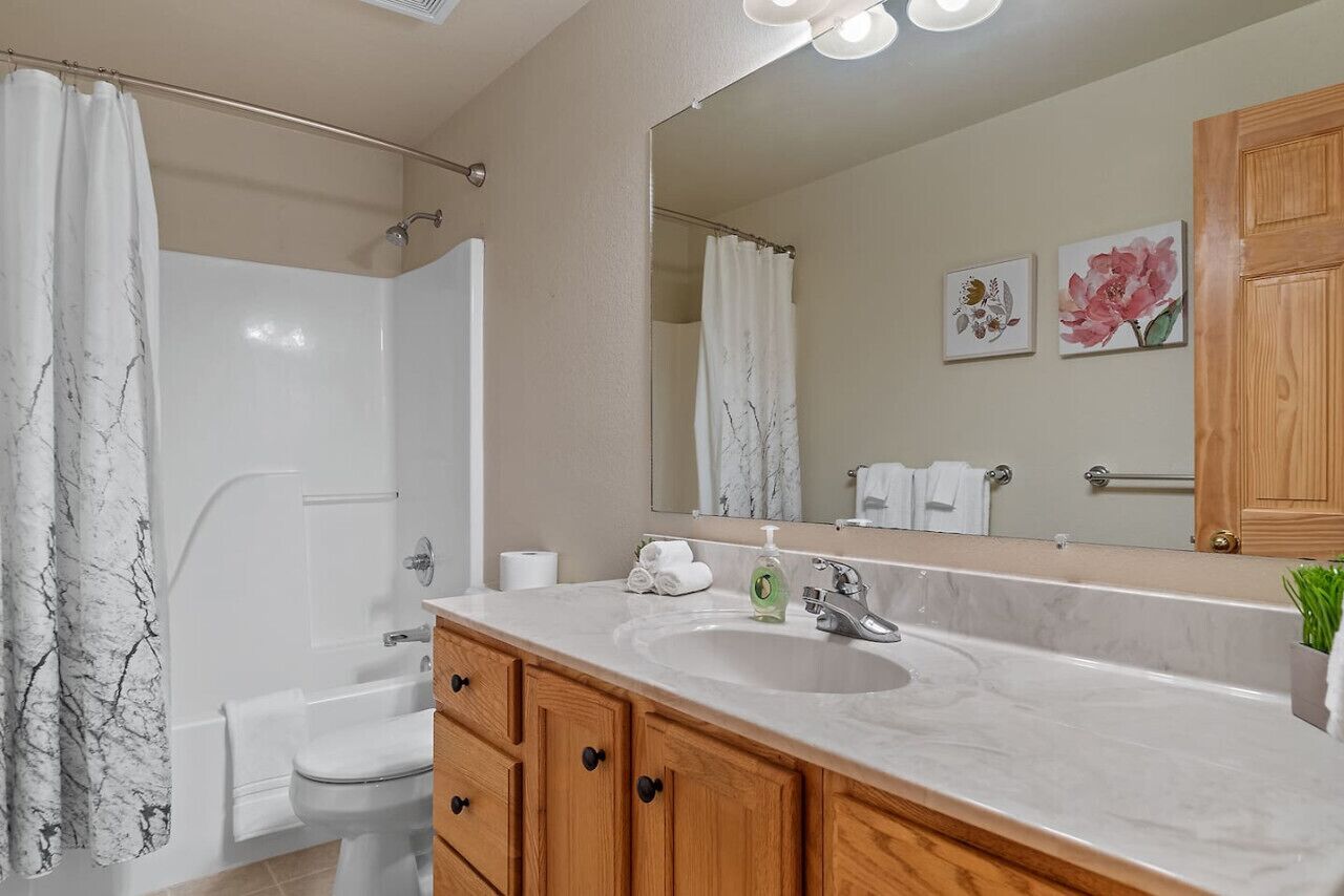 A bathroom with a shower, toilet, and sink.