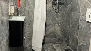 Ein Badezimmer mit Dusche, Toilette und Waschbecken.