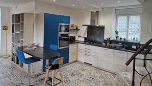 A modern kitchen with a central island, built-in oven, and a gas stove.