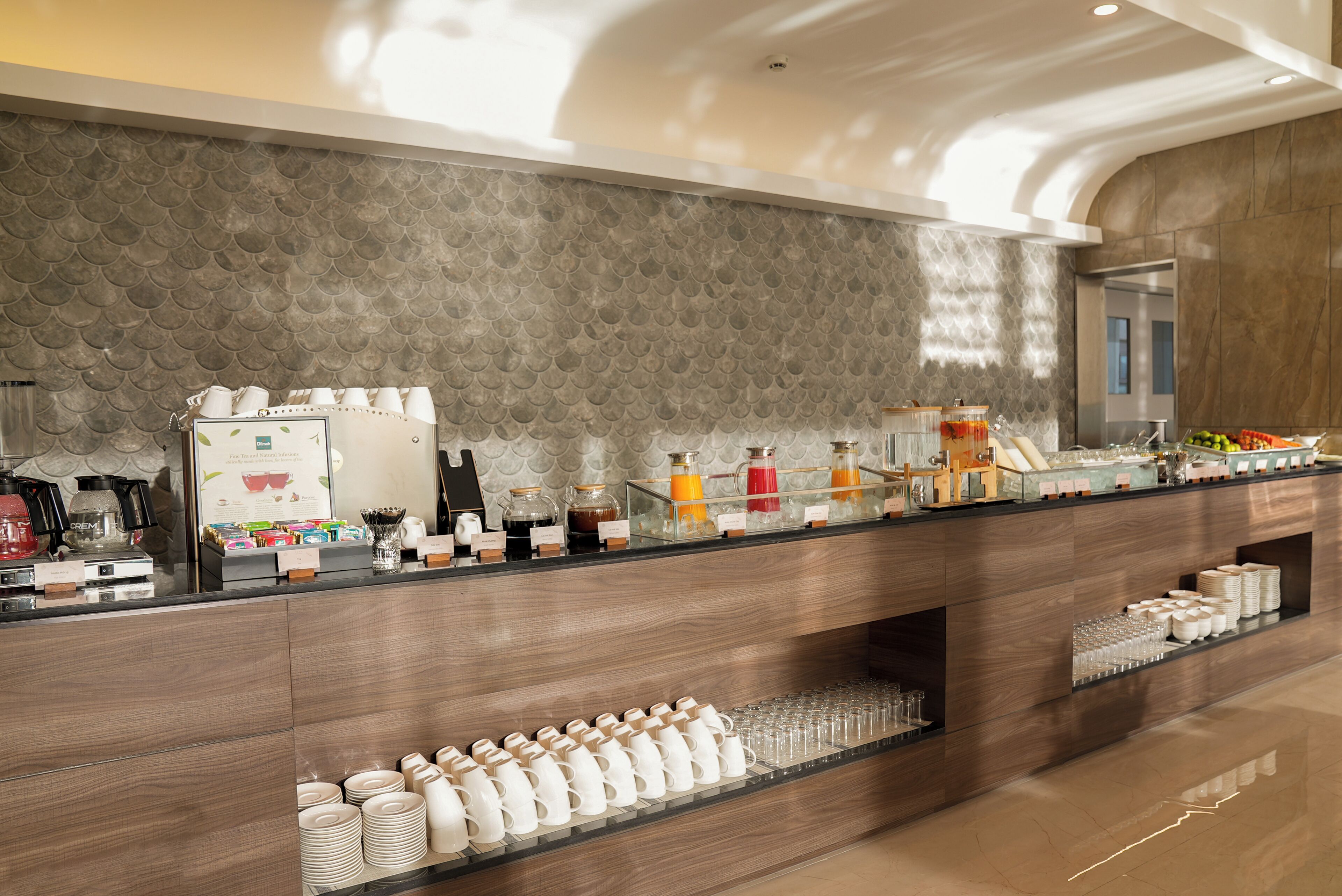 Un espace d’accueil moderne, avec un coin café, de la verrerie et une variété d’aliments pour le petit-déjeuner.