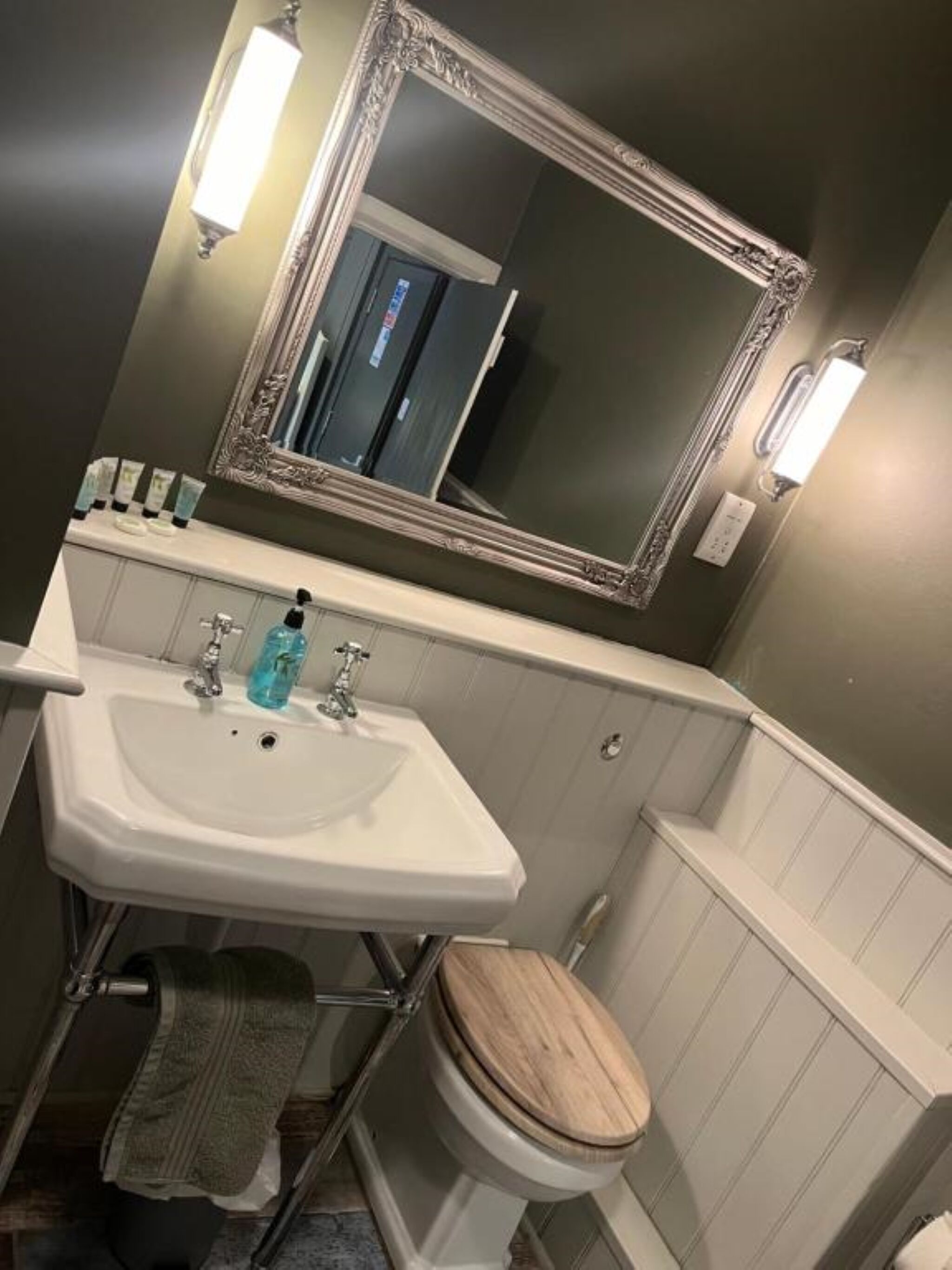 Un baño con un lavabo blanco, un espejo y un inodoro.
