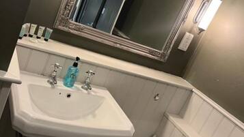 Un baño con un lavabo blanco, un espejo y un inodoro.