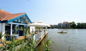 A waterfront property with a dining area, a covered outdoor seating area, and a boat dock.