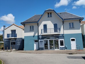 A two-story building with a sign for 'POISSONNERIE DE BOURGENAY' and a smaller adjacent building labeled 'Donnazurra Pizzeria Restaurante Bar'.