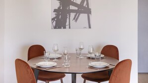 Et spisebord dækket med tallerkener, glas og bestik, omgivet af stole.