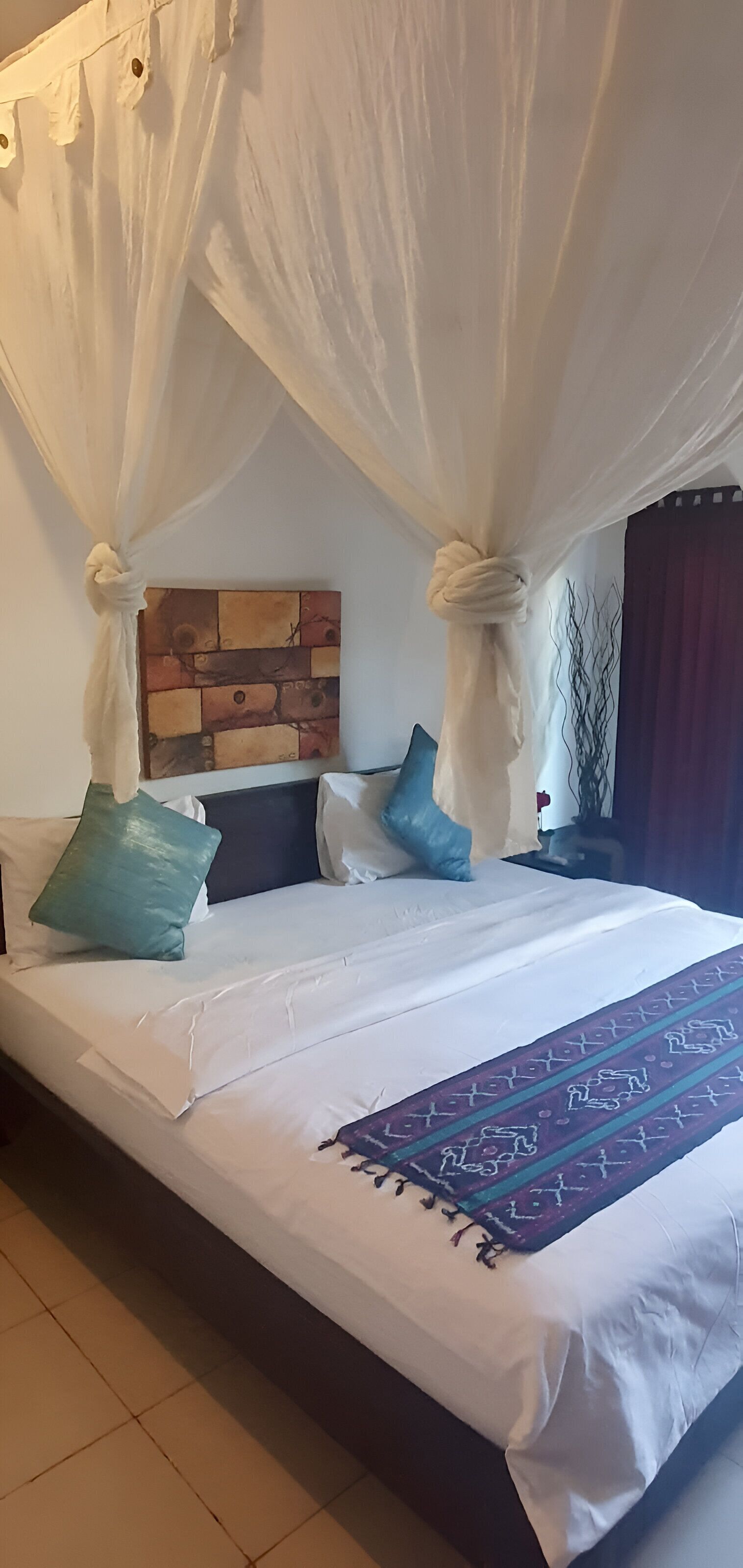 Ein Bett mit Baldachin, einem Kopfteil und einer Wanddekoration.