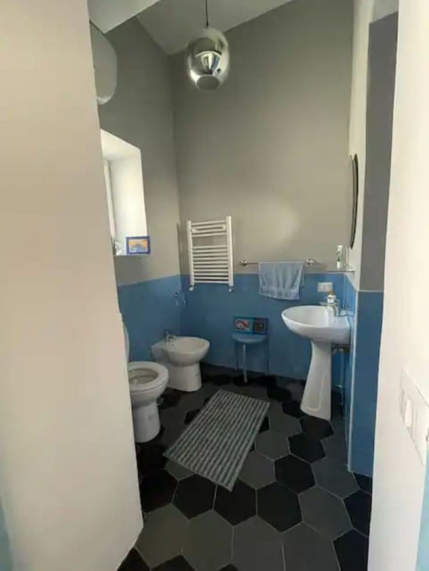 Ein Badezimmer mit Toilette, Bidet, Waschbecken und Handtuchhalter.
