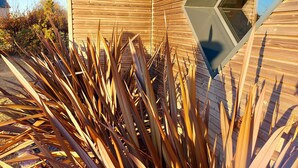 Un edificio moderno con fachada de madera y una ventana triangular distintiva.