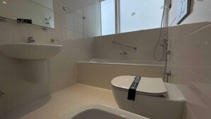 A modern bathroom with a white sink, toilet, and bathtub. - Spacious Furnished Apartment in Palette Tower in Tourist Club Area (Abu Dhabi)