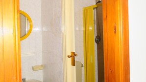 A bathroom with a toilet, sink, and shower area. - Apartment with balcony (Lipari)