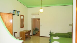 A room with a bed, a desk, a chair, and a television. - Apartment with balcony (Lipari)