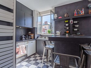 Enjoy a city view from the kitchen's large window, featuring a bar area with a wine rack and modern amenities.