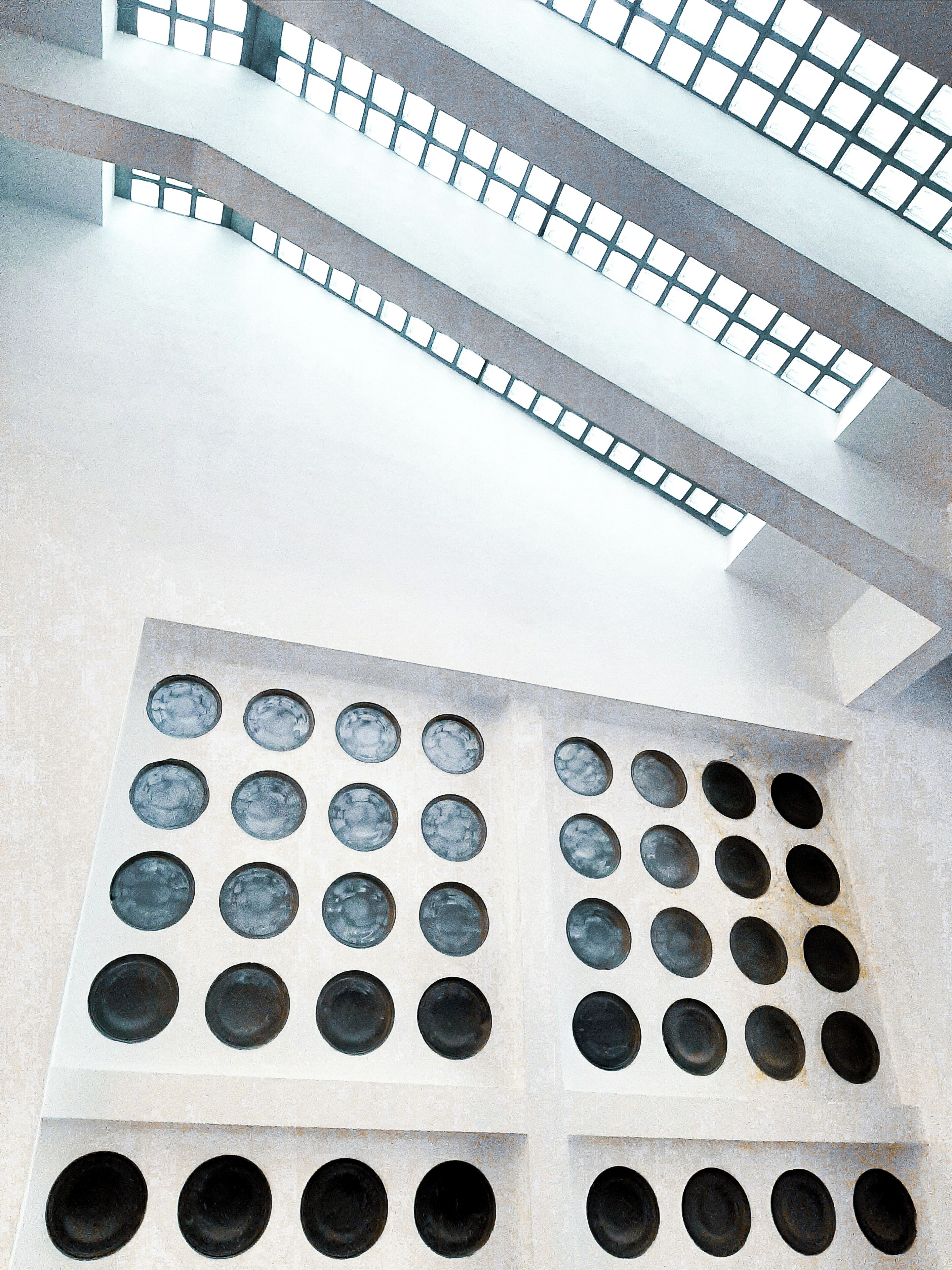 Un edificio moderno con una serie de ventanas circulares y una escalera que conduce a un nivel superior.