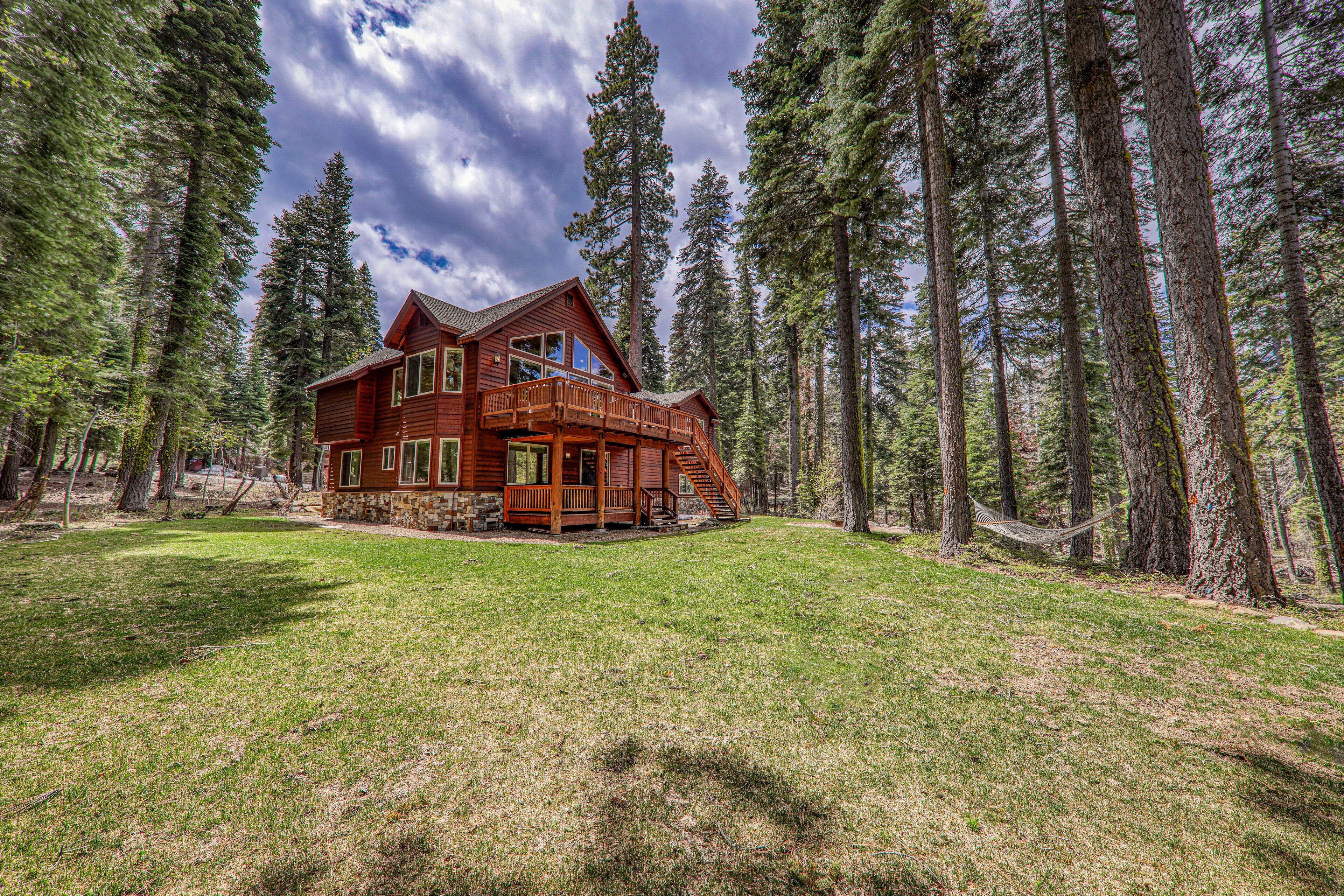 A large wooden cabin surrounded by tall pine trees.