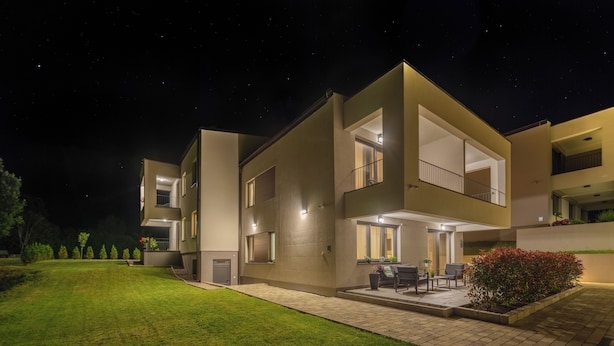 A modern two-story residential building with a well-maintained lawn and outdoor seating area. - PLITVICE LACUS (Rakovica)