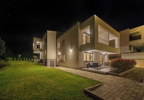 A modern two-story residential building with a well-maintained lawn and outdoor seating area. - PLITVICE LACUS (Rakovica)