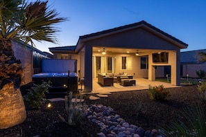 A modern house with a covered patio, outdoor seating, and a hot tub. - Double Bogey Jackpot by J and Amy BL991951 (Mesquite)