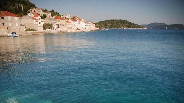 A coastal town with clear waters, rocky shoreline, and traditional buildings. - Apartment Luca (Vodice)